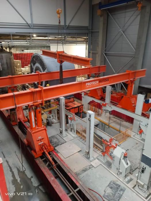 Transport wielkogabarytowego cylindra papierniczego na platformie samojezdnej w hali produkcyjnej. 