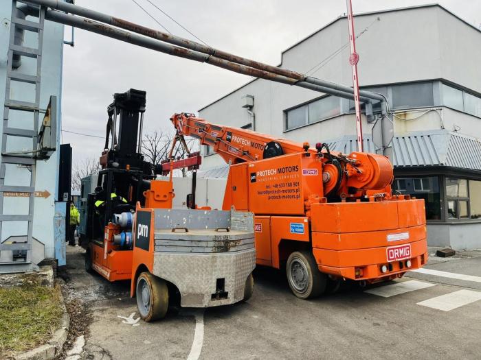 Dźwig samojezdny Ormig podnosi maszynę do produkcji śrub podczas relokacji w województwie śląskim. 