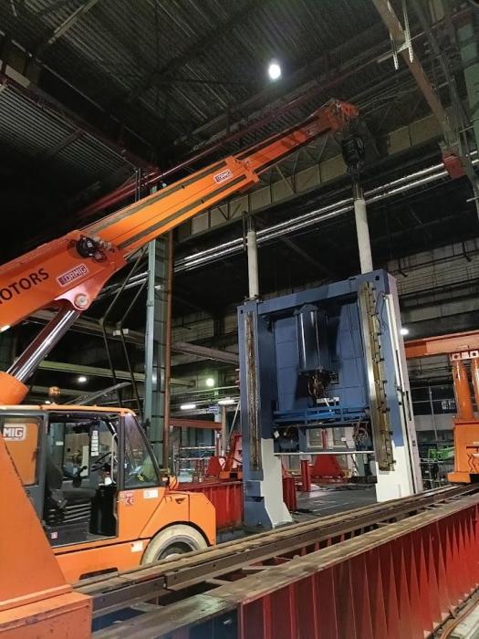 Podnoszenie górnej części prasy mechanicznej AIDA przy użyciu dźwigu Ormig w hali produkcyjnej. 