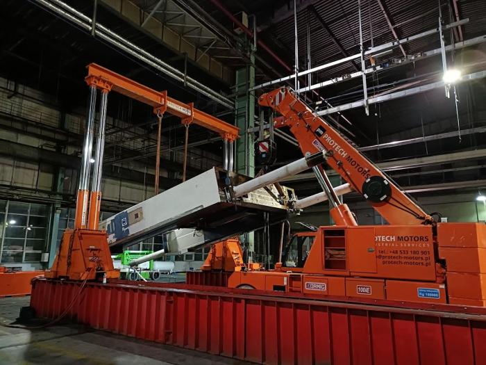 Opuszczanie korpusu prasy mechanicznej AIDA przy użyciu dźwigu i systemu podparć hydraulicznych. 