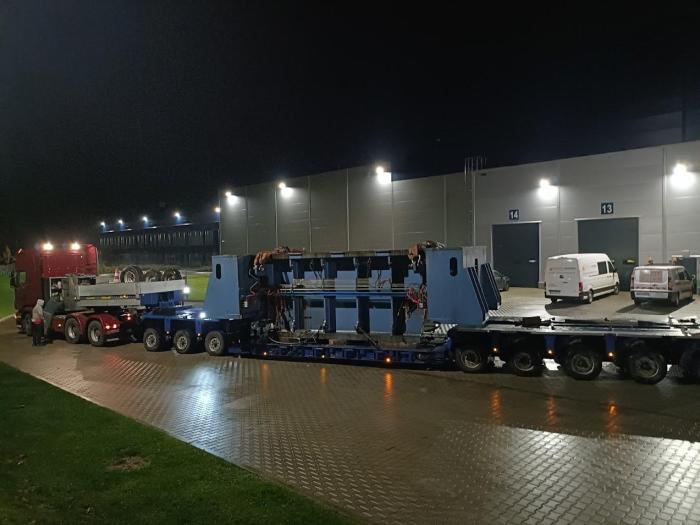 Transport korpusu prasy mechanicznej na naczepie niskopodwoziowej w godzinach nocnych. 