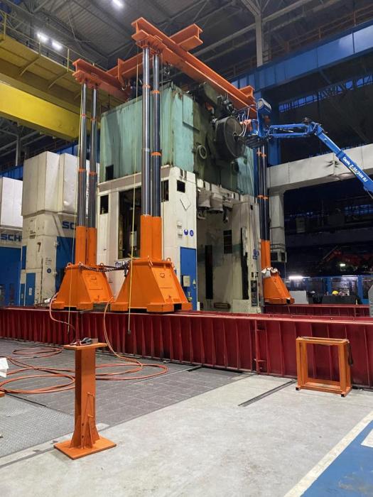 Unoszenie korpusu prasy mechanicznej przy użyciu czterech siłowników hydraulicznych. 