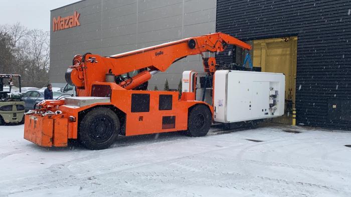 VALLA realizujący montaż maszyny CNC przy hali produkcyjnej w warunkach zimowych. 