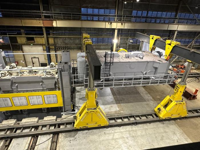 Hydrauliczna suwnica bramowa ENERPAC SBL 1100 podczas transportu ciężkiego walca przemysłowego. 