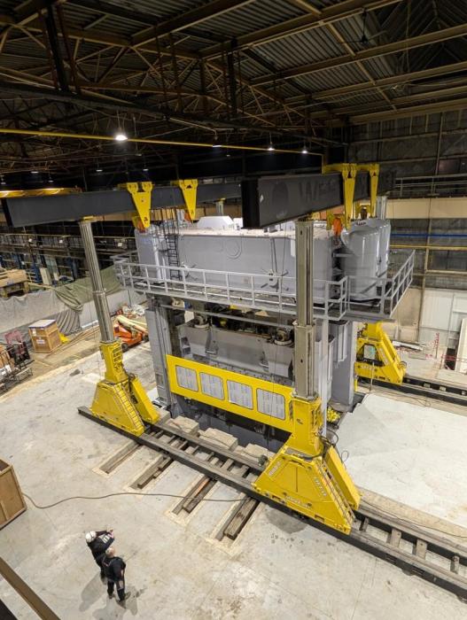 Suwnica ENERPAC SBL 1100 podczas precyzyjnego montażu ciężkiej maszyny w zakładzie przemysłowym. 